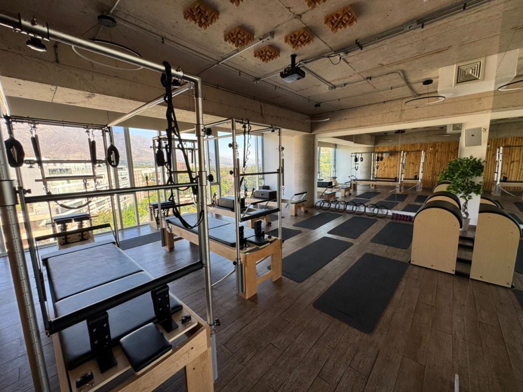 Sala de Pilates Reformer en Los Dominicos las condes con reformer cadillac stepchair ladder barrel y vista panorámica.